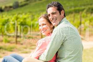 Portrait of happy couple sitting in vineyard