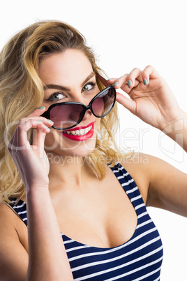 Portrait of beautiful woman posing with sunglasses against white background