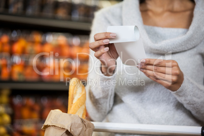 Mid section of woman holding bill