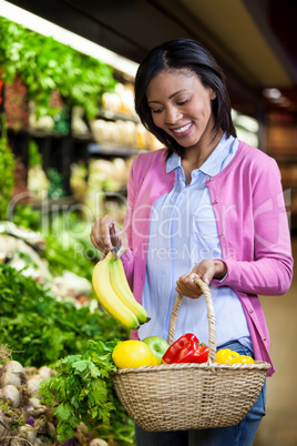 Woman buying banana in organic section