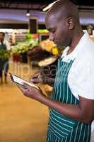 Male staff using digital tablet in organic section