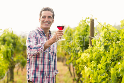 Smiling vintner holding glass of wine