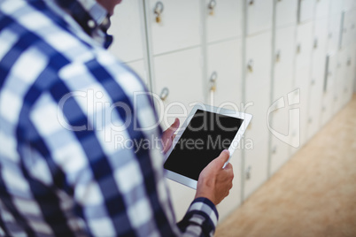 Student using digital tablet in locker room