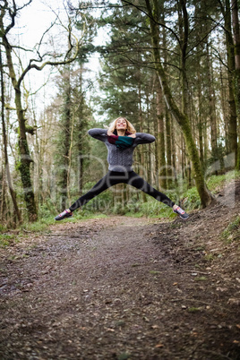 Beautiful woman jumping in forest