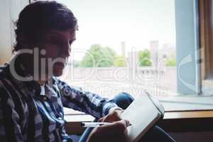 Student writing notes near window