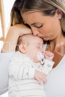 Mother holding and kissing her baby boy