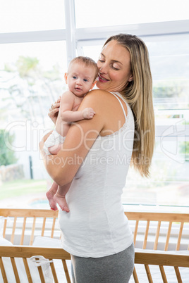 Mother carrying her baby in living room