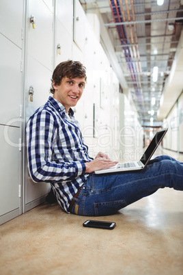 Student using laptop in locker room