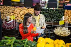 Couple checking their notepad while shopping in organic section
