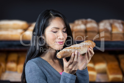 Woman smelling a baguette