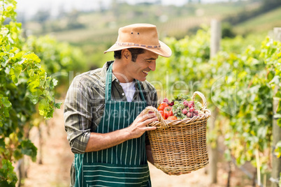 Happy farmer holding a basket of vegetables