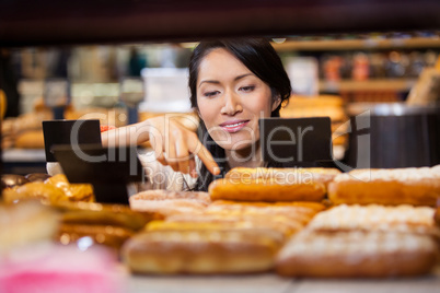 Woman selecting baguettes from bread counter