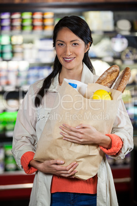 Woman holding groceries in paper bag