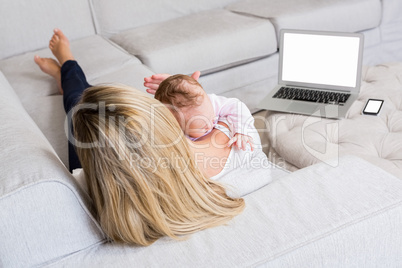 Mother carrying her baby in living room