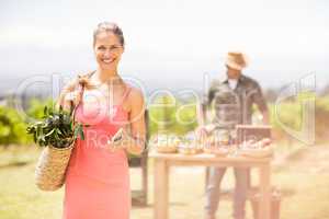 Portrait of female customer standing in front of vegetable stall