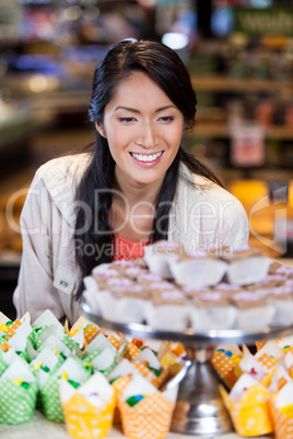 Happy woman looking at cupcakes