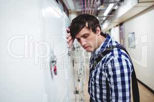 Sad student leaning on locker