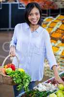 Woman buying vegetables and fruits in organic section