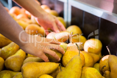 Male staff arranging fruits in organic section