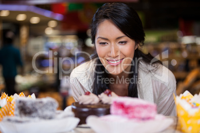 Happy woman selecting desserts from display
