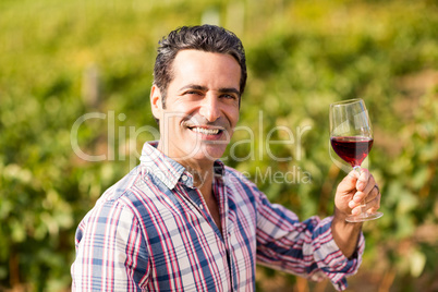 Portrait of smiling male vintner holding a glass of wine