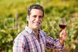 Portrait of smiling male vintner holding a glass of wine