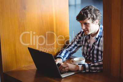 Student using laptop while having coffee