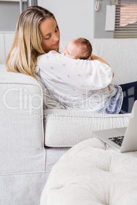 Mother carrying her baby in living room