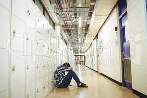 Depressed student sitting in locker room