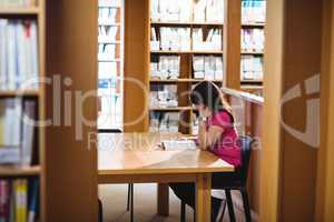 Female student reading book in college library
