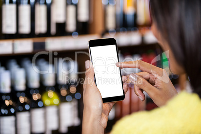 Woman using mobile phone in grocery section