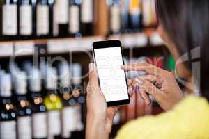 Woman using mobile phone in grocery section