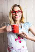 Smiling woman in apron holding a coffee mug against texture background