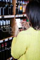 Woman using mobile phone in grocery section