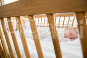 Baby boy sleeping on a cradle