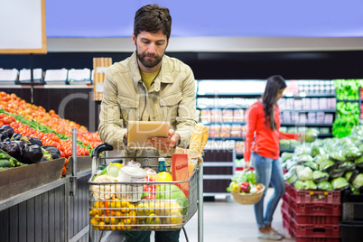 Man using digital tablet while shopping