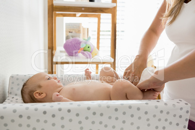 Mother changing the diaper of her baby