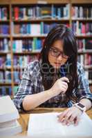 Female student looking at notes in library