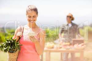 Female customer using mobile phone in front of vegetable stall