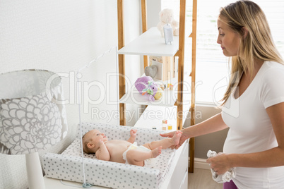 Mother changing the diaper of her baby