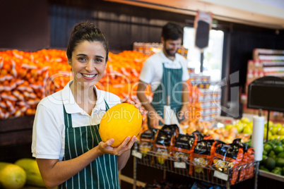 Female staff holding vegetable in supermarket