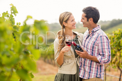 Happy couple holding glass and a bottle of wine