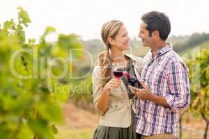 Happy couple holding glass and a bottle of wine