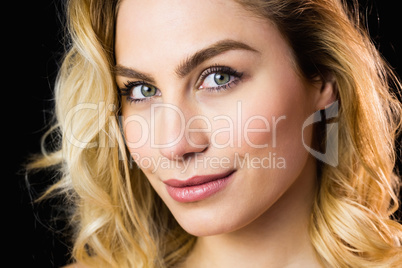 Portrait of beautiful woman smiling against black background