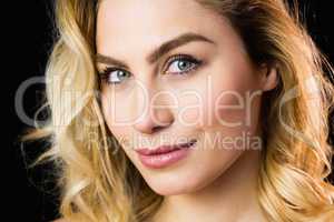 Portrait of beautiful woman smiling against black background