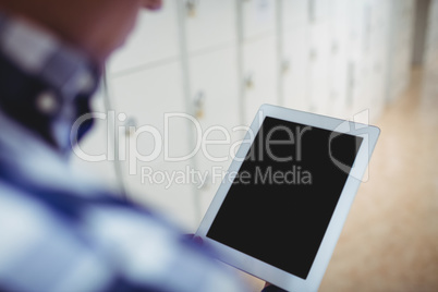 Student using digital tablet in locker room