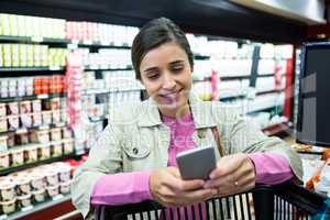 Woman using mobile phone while shopping