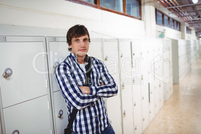 Portrait of student standing with arms crossed in locker room