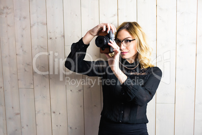 Woman clicking photo from camera against texture background