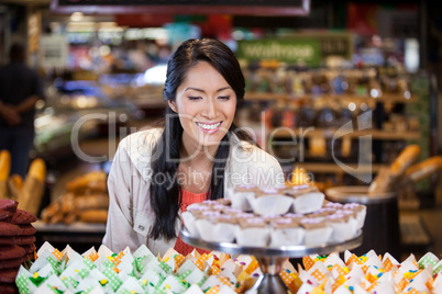 Happy woman looking at cupcakes